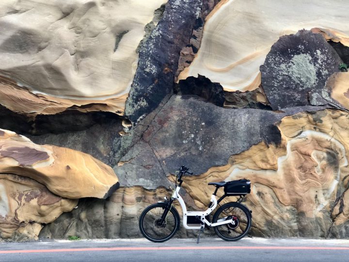 e-bike in front of a big colourful rock